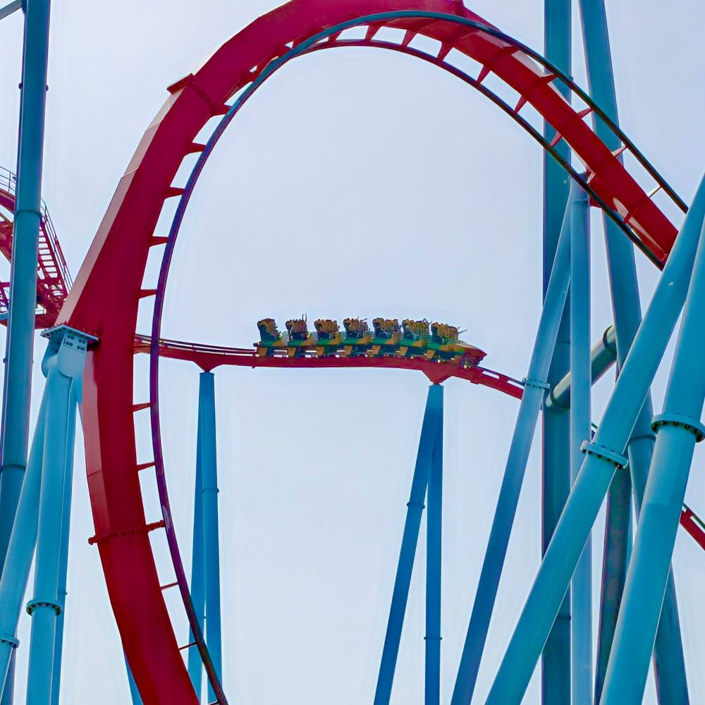 Tren de Dragon Khan atravesando el pre-drop entre raíles rojos y soportes azules