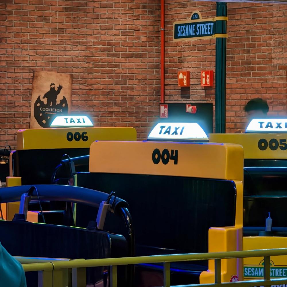 Taxis de Street Mission con la luz encendida junto al cartel Sesame Street