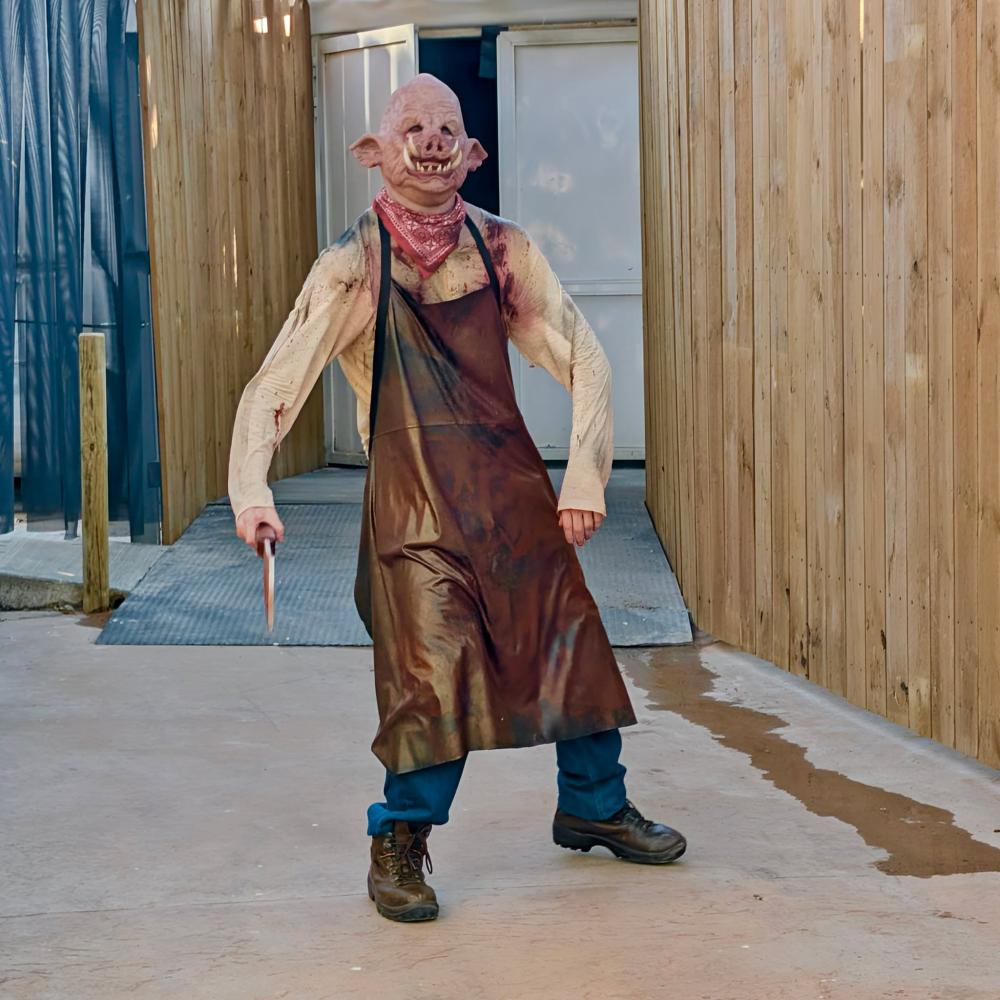 Actor del Carnicero de Penitence con máscara de cerdo y cuchillo