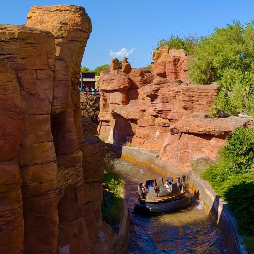 Barca de Grand Canyon Rapids navegando entre rocas rojizas en PortAventura